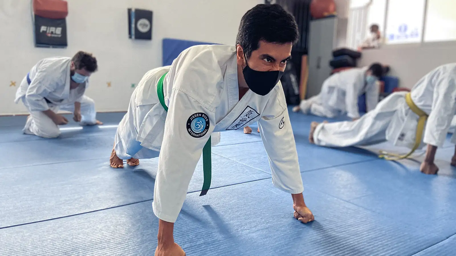 Escuela de artes marciales, adulto practicando karate realizando ejercicio de fuerza