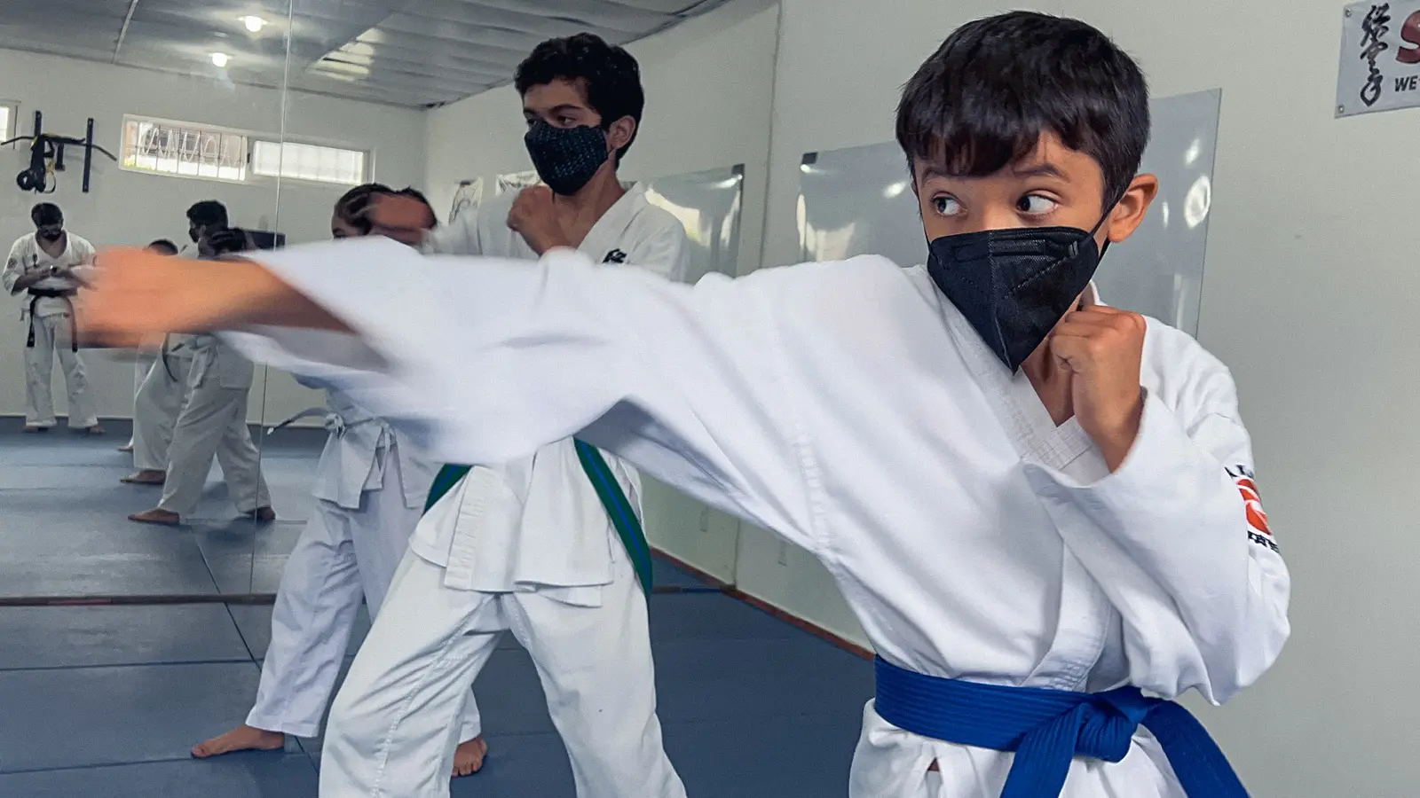 Niño practicando karate realizando un golpe con la mano derecha
