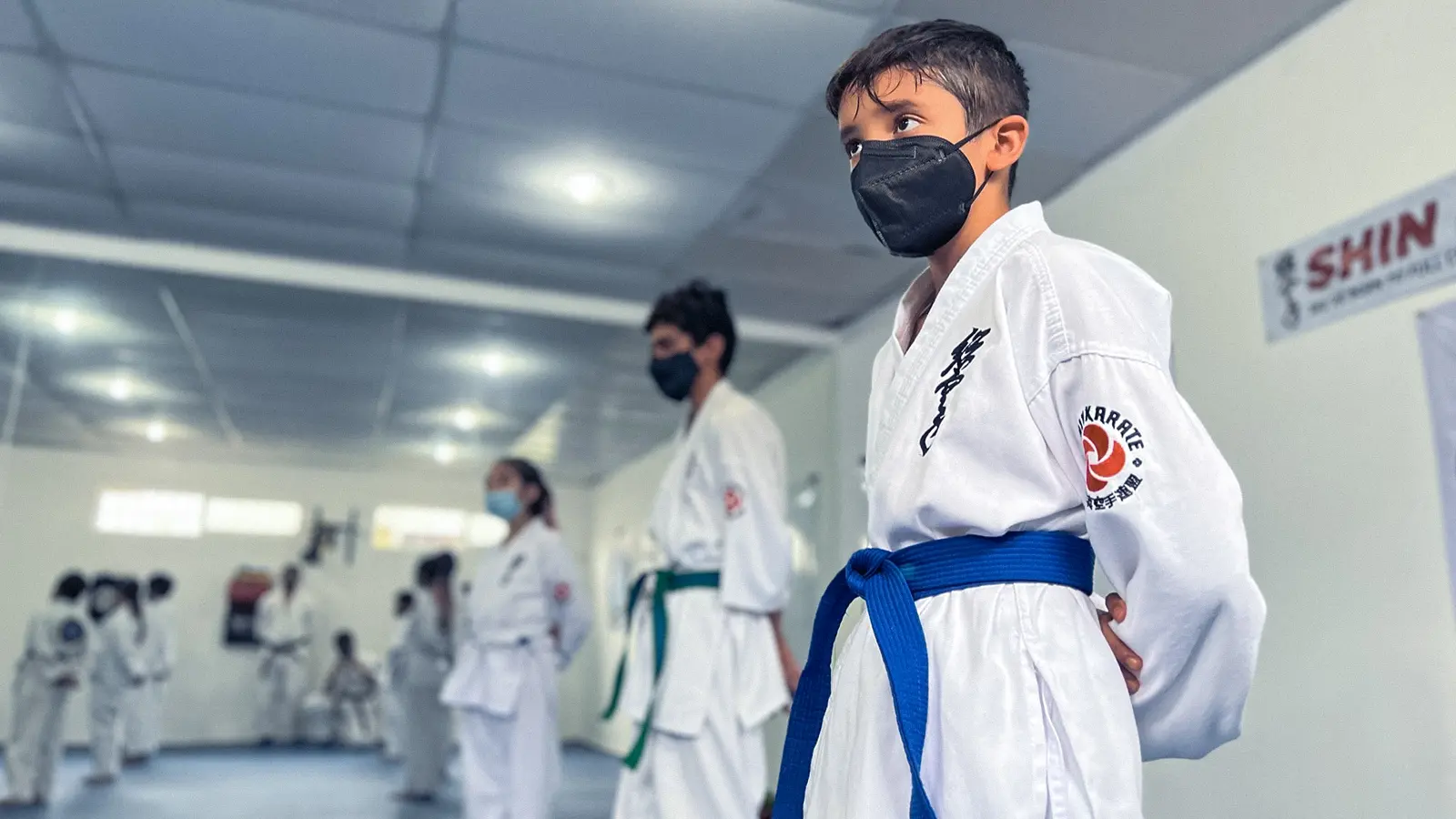 Niño practicando karate con una expresión y postura seria, viendo a la cámara
