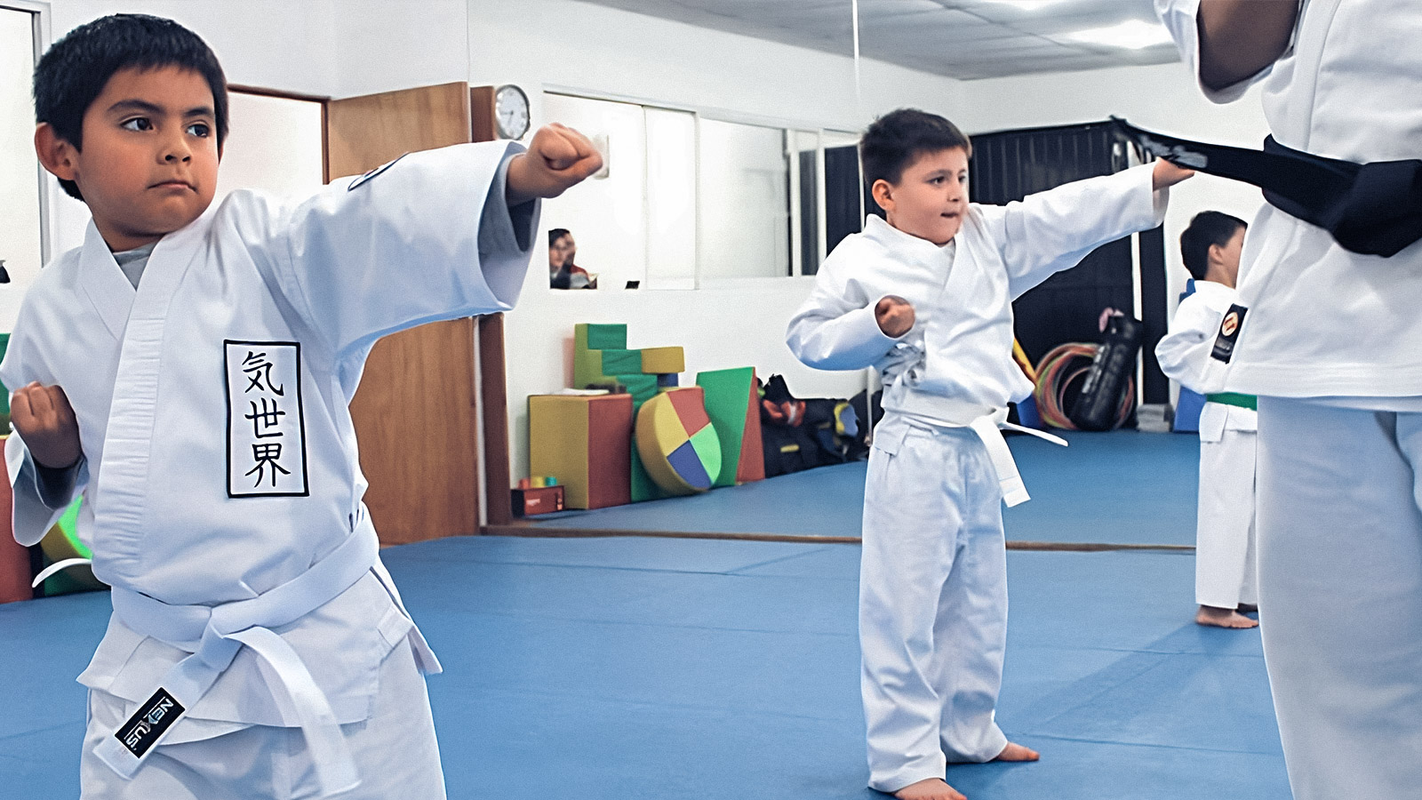 Niños pequeños practicando karate, dando golpes al aire