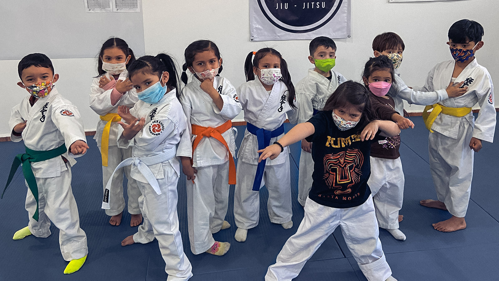 Niños pequeños practicando karate, jugando en su clase de karate